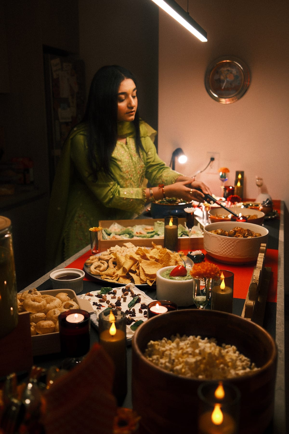 Toronto Canteen family-style grazing table with biryanis, curries, dips, candles, and fresh herbs laid out for a private dinner